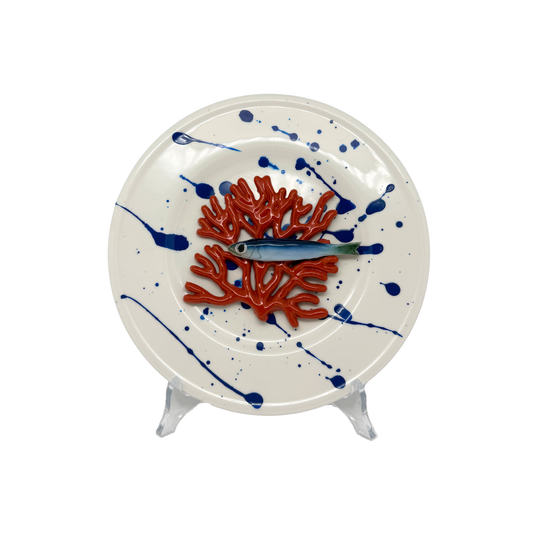 Koraal piccolo met sardientje op wit bord met blauwe verfspetters, 21 cm rond.