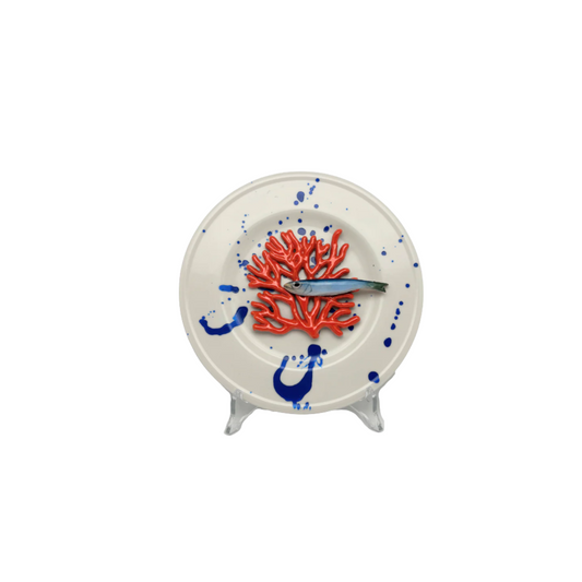 Koraal piccolo met sardientje op wit bord met blauwe verfspetters, 21 cm rond.